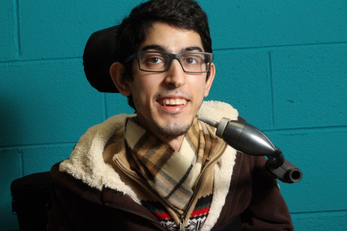 A young man in a wheelchair happy to have access to his mobile device through the LipSync.