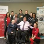 A group photo against a backdrop of Neil Squire Society and Makers Making Change banners