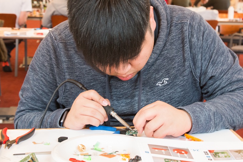 A student focusing on soldering