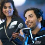 Omar speaking with Shelina Dilgir, Associate Director of Development, holding up the mic