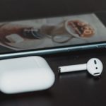 Apple AirPods with an iPhone in the background