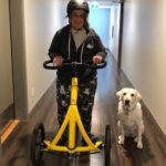 Tech for Good participant Amber, walking down a corridor with her dog