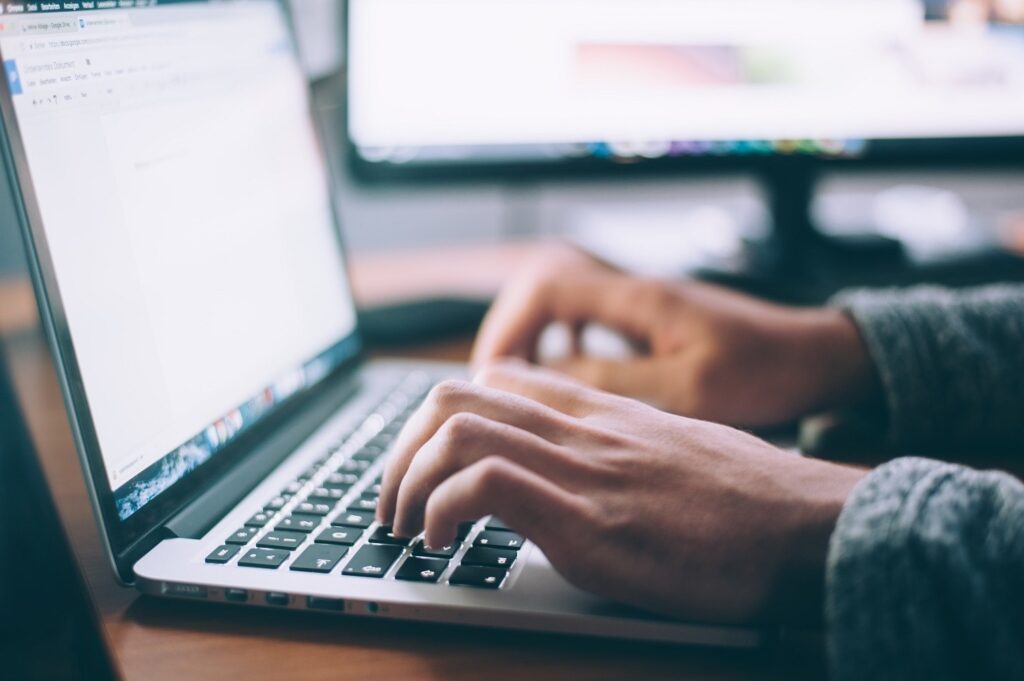 close-up of person typing at a laptop