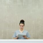 stock image of a woman using a clipboard while standing in a hallway
