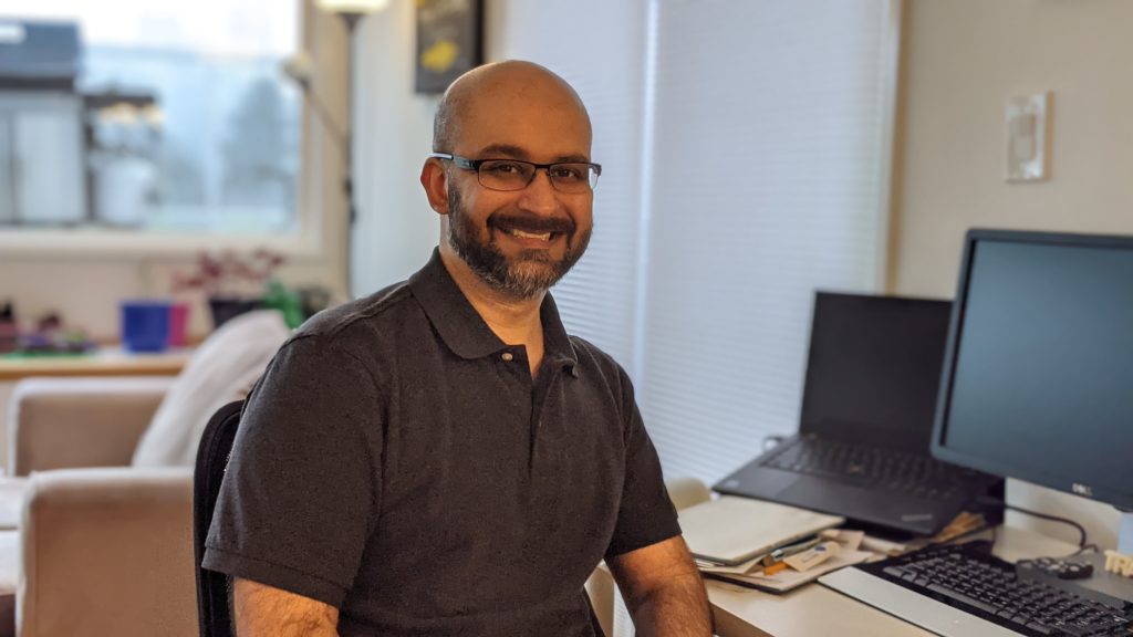Imtiaz seated at his desk, smiling
