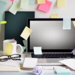 A laptop with a number of post-its all over it