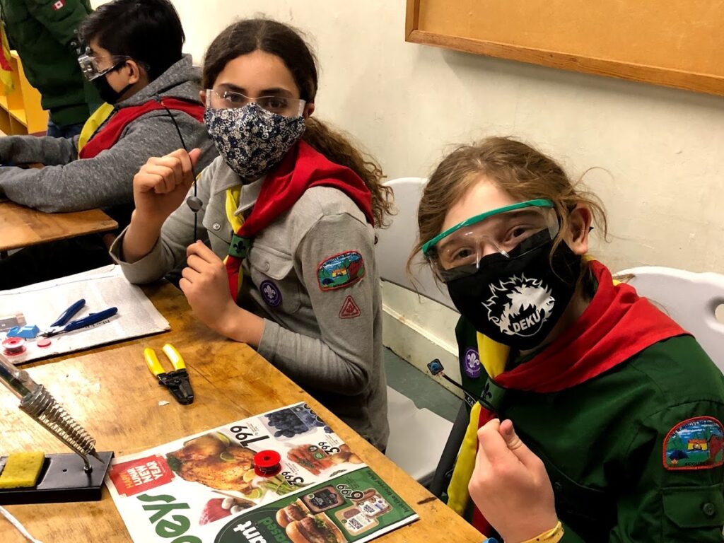 Two scouts show off their devices.