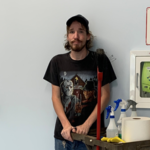 Luke at work. He is leaning against the wall, with cleaning equipment next to him