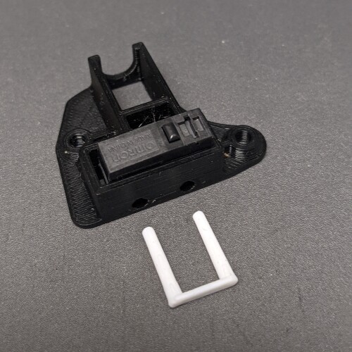 a set of 3D printed pins sitting next to the internal switch components of a Round Flexure Switch