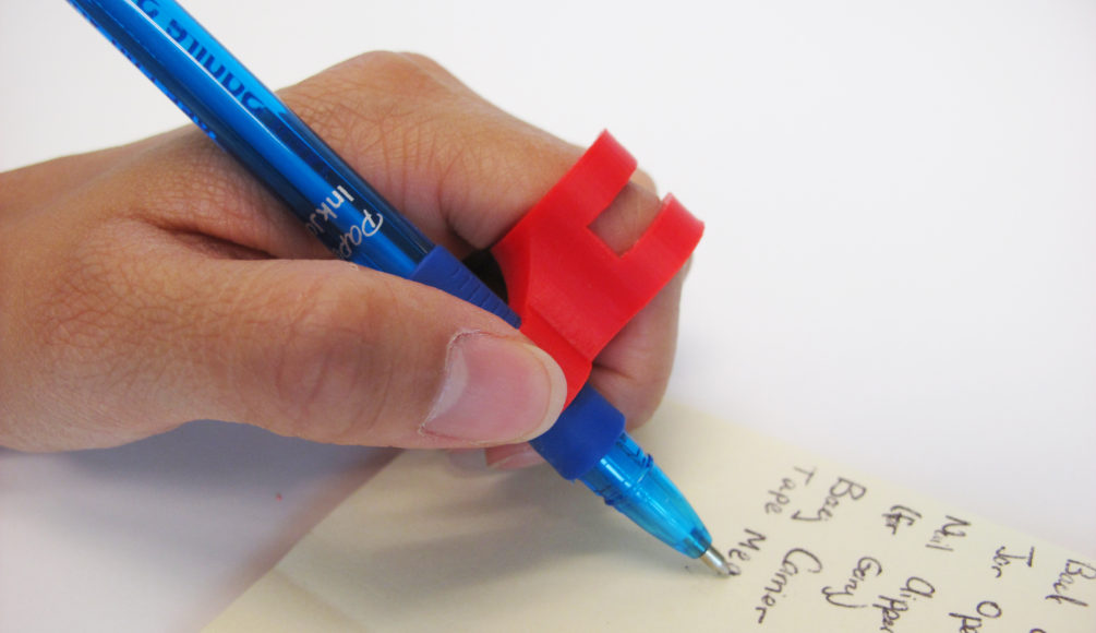 A user using the 3D Printed finger pen holder to write with ease