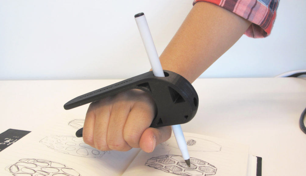 A user using the 3D Printed Palm Pen Holder to draw on a piece of paper with ease