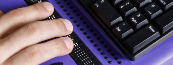 a hand hovers over an assistive keyboard
