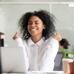 a person celebrating an achievement while going on the computer