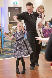 a man dances with his two young daughters