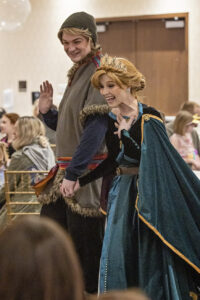 a Storybook Princess and Prince greet the crowd as they enter