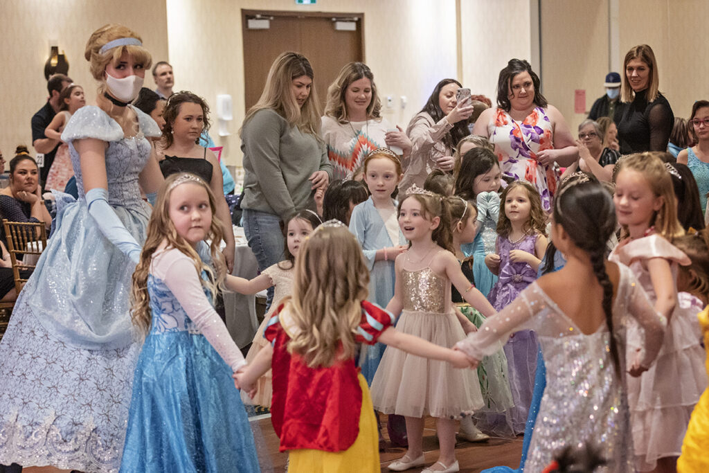 young girls in princess costumes dance with a Storybook Princess at the 2022 Princess Ball