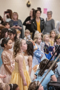 little girls at the 2022 Princess Ball look over at the stage
