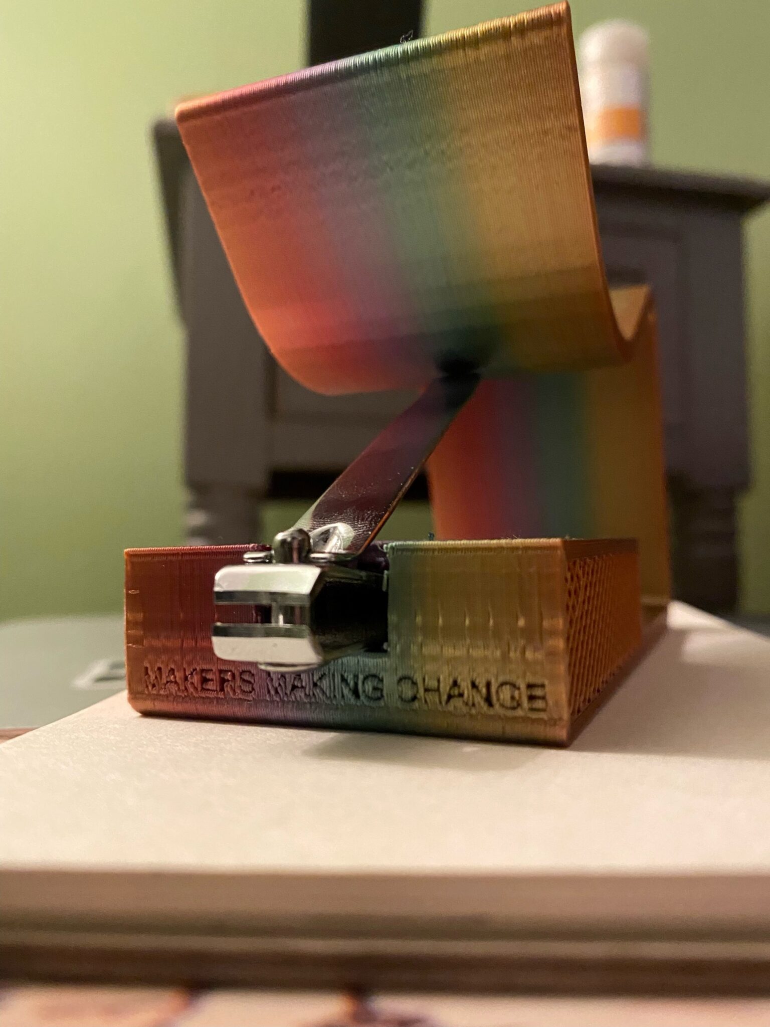 a rainbow-colored 3D printed Nail Clipper Holder with a nail clipper inside