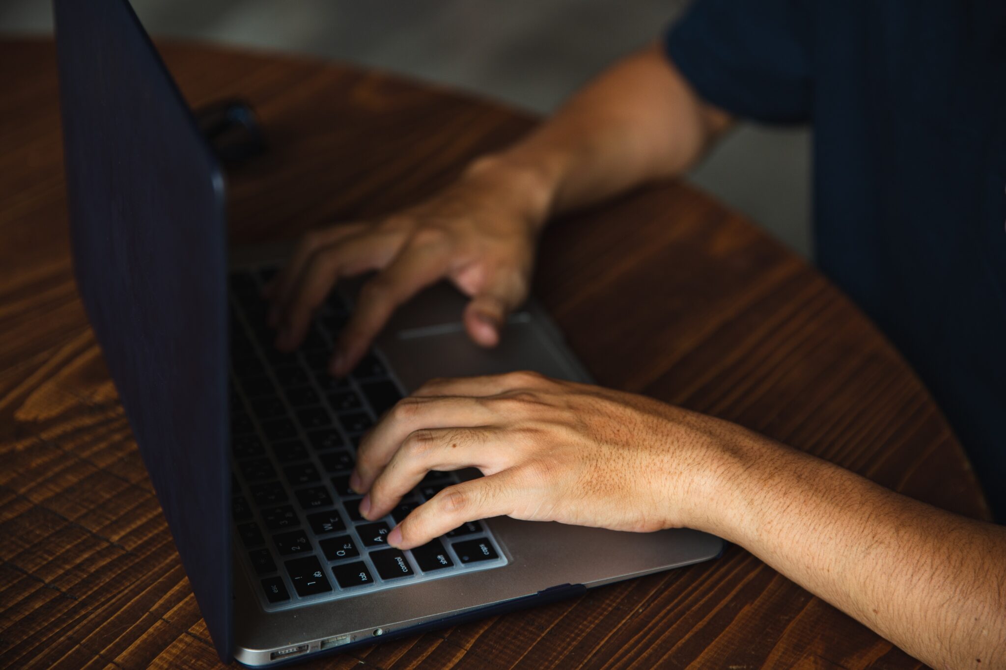 a man typing on a laptop