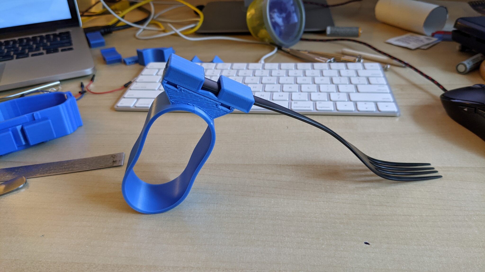 A blue 3d printed universal cuff with a fork