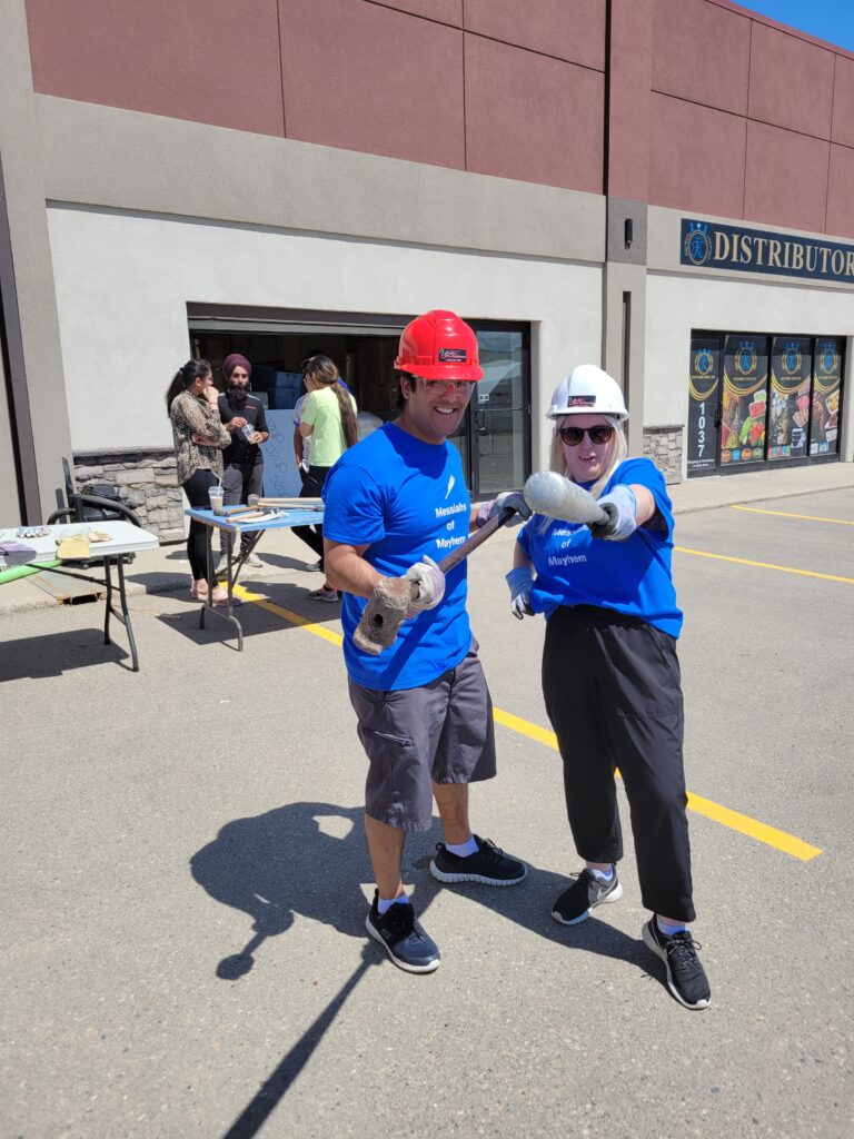 Pran and Chelsea posing with a baseball bat and a sledgehammer