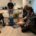 Neil Squire Prairie Region Office staff practicing using the AED on a dummy