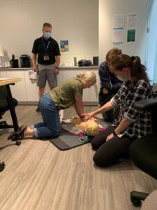 Neil Squire Prairie Region Office staff practicing using the AED on a manikin