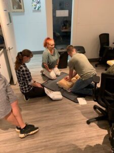 Neil Squire Prairie Region Office staff practicing using the AED on a manikin
