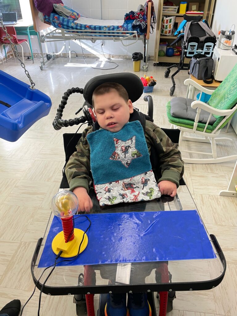 Felix in a wheelchair playing with his new adapted toy