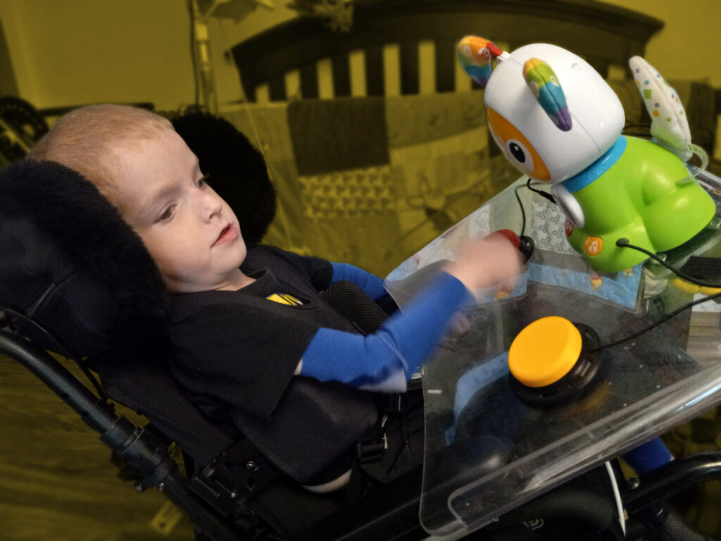 A child in a wheelchair using switches to activate an adapted toy