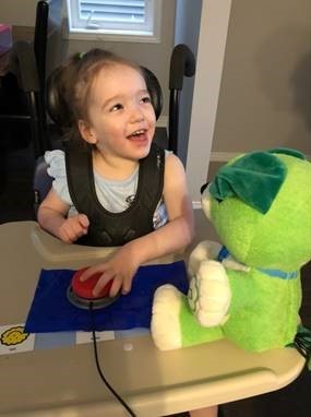 Aubrey playing with an adapted toy using a switch