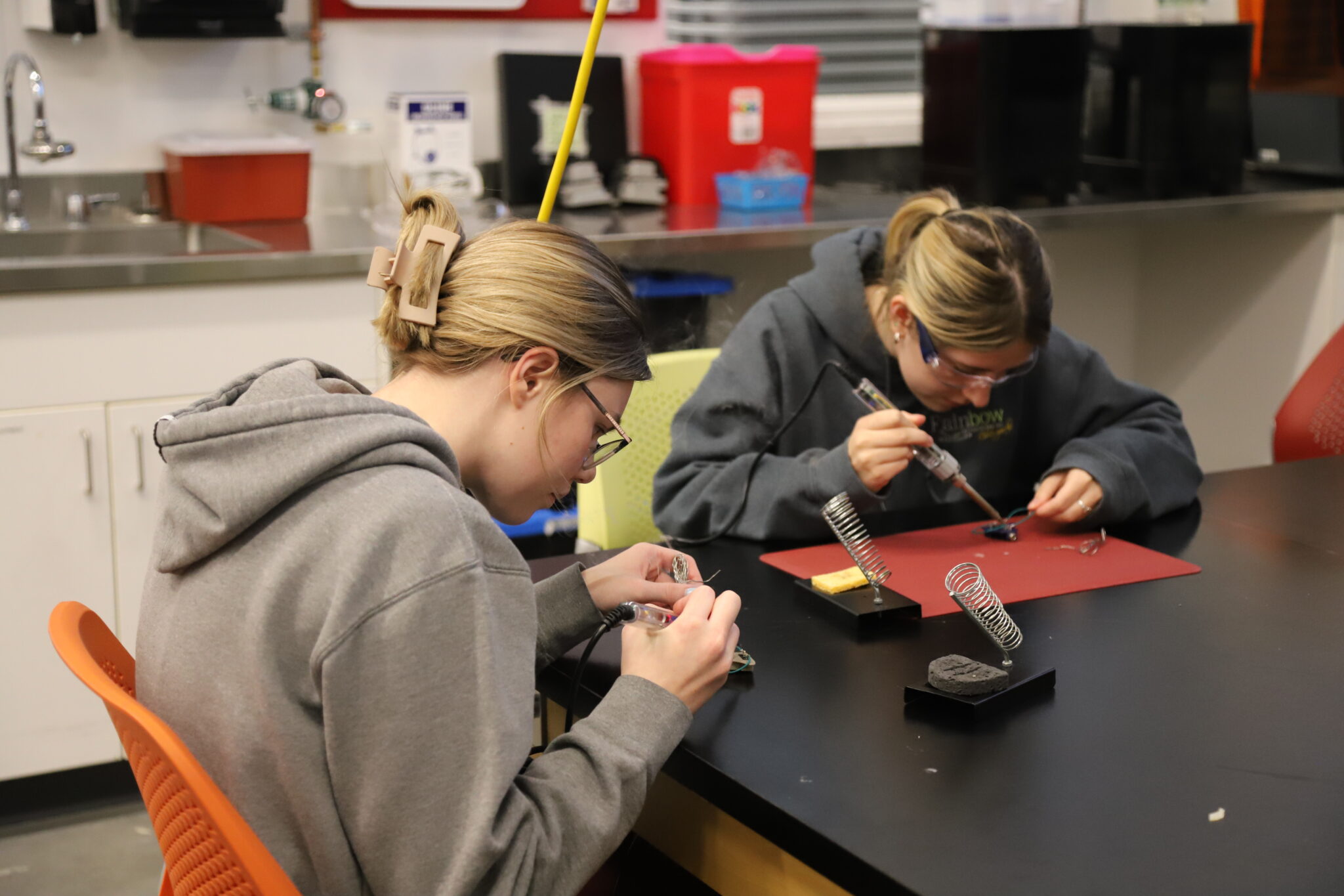 two students soldering