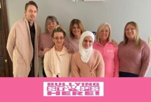 our staff in New Brunswick wearing pink, with the banner "Bullying stops here"