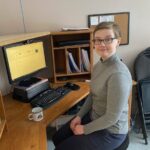 Working Together participant Emily sitting at her work desk on her wobble chair