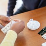 a care aid preparing pills for a senior