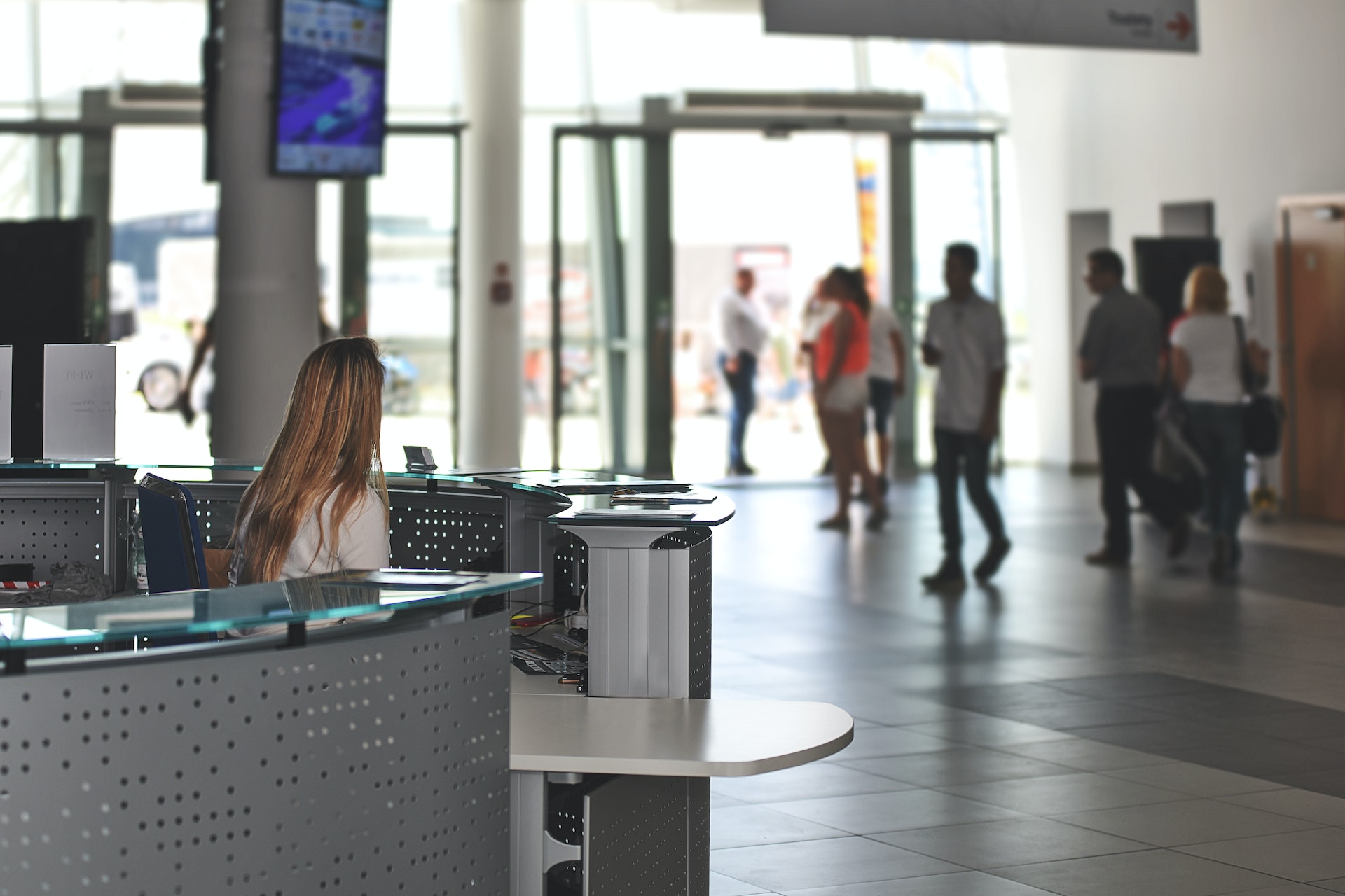 a receptionist sits at her desk in a busy building