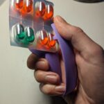 a Blister Pack Opener being used to open a blister pack with pills inside