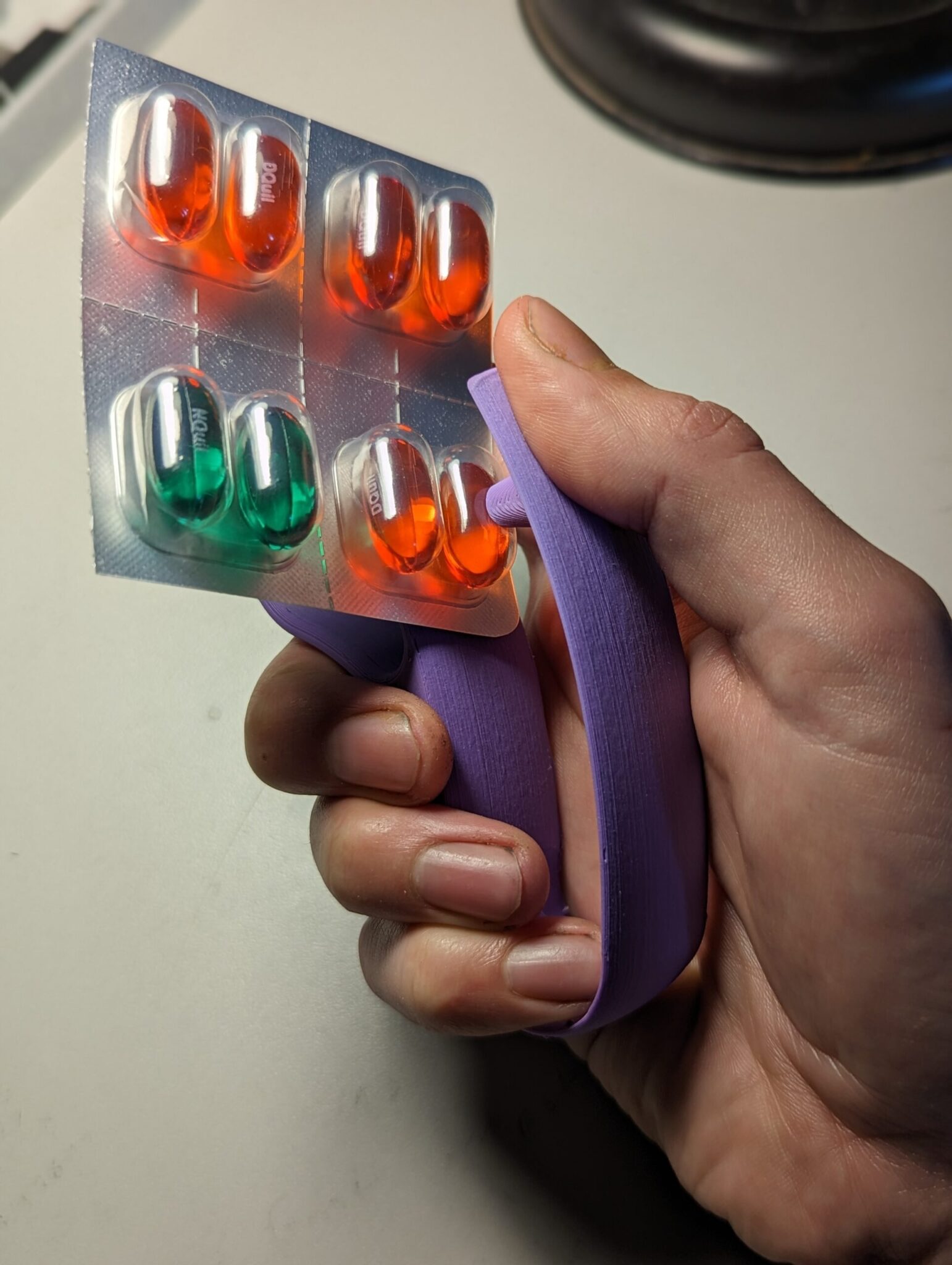 a Blister Pack Opener being used to open a blister pack with pills inside
