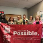 Job Developer Merit, Prairie Regional Manager Nikki, and the Manitoba Possible team pose with a Manitoba Possible banner