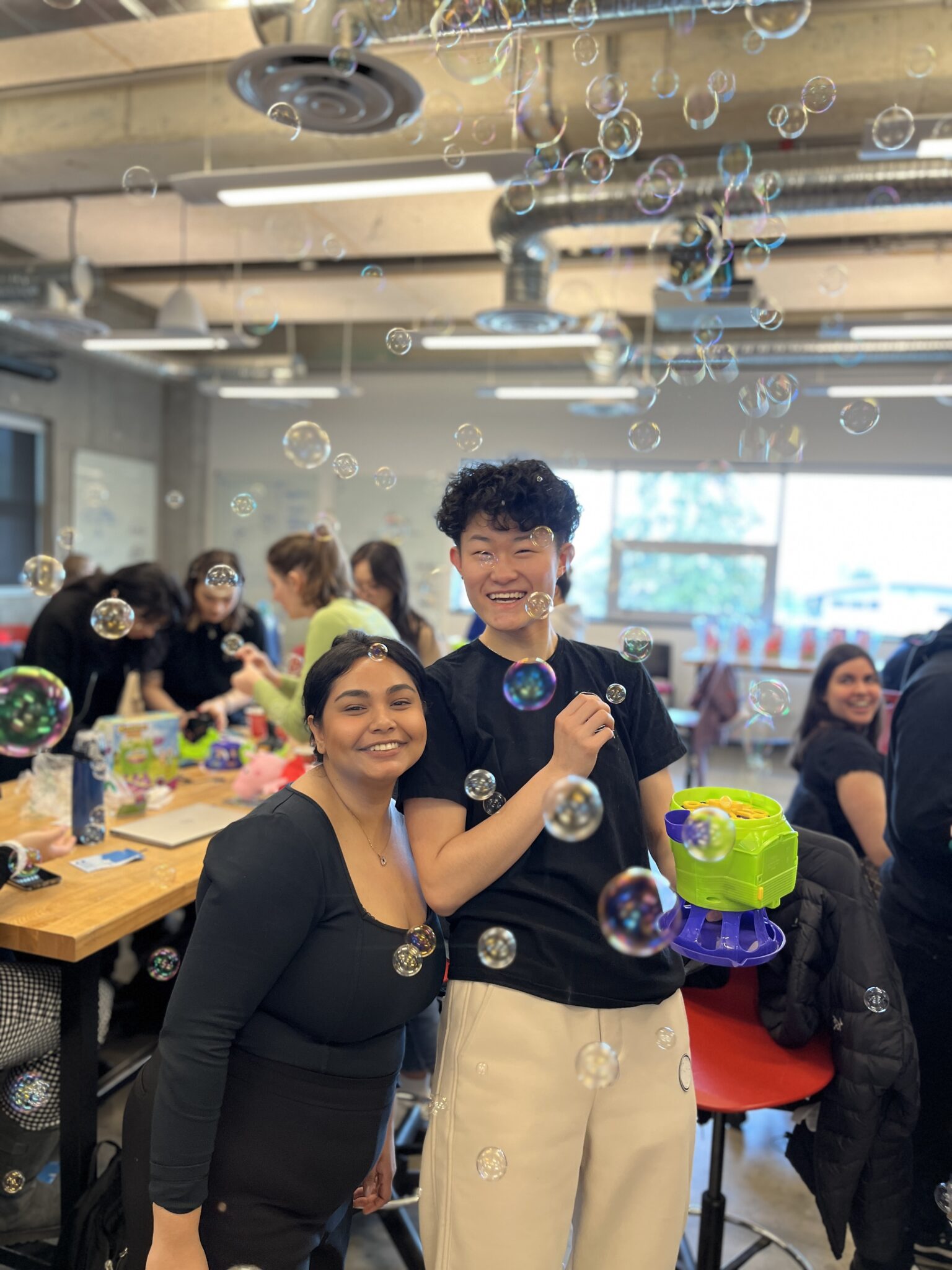 postsecondary student makers showing off an adapted bubble blower toy that they worked on