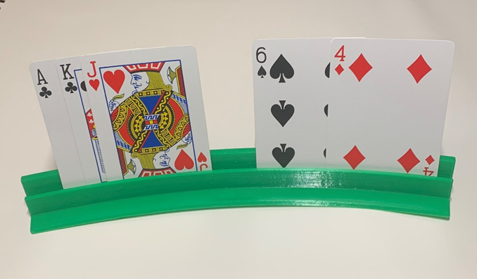 Green 3D printed device holding various playing cards