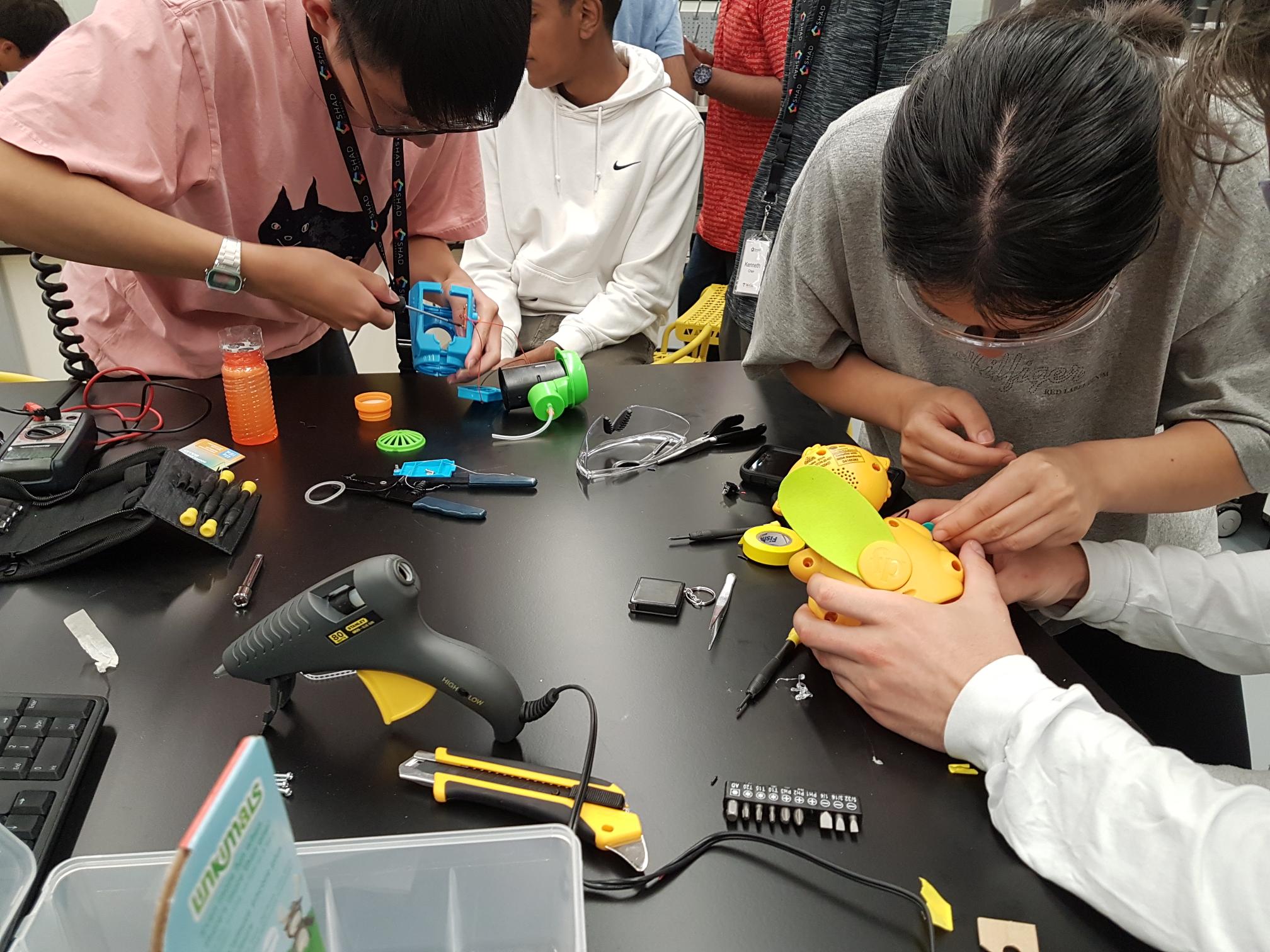 Students building devices at a build event.