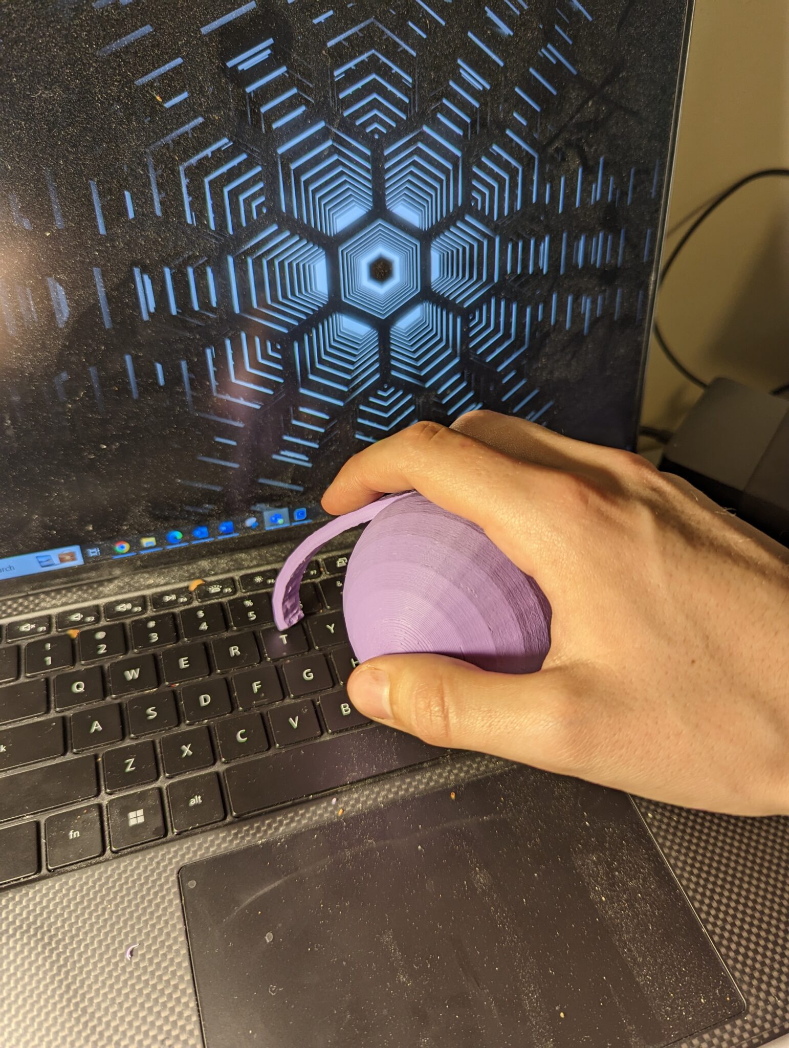Typing with the arthritis typing aid on a black computer keyboard.