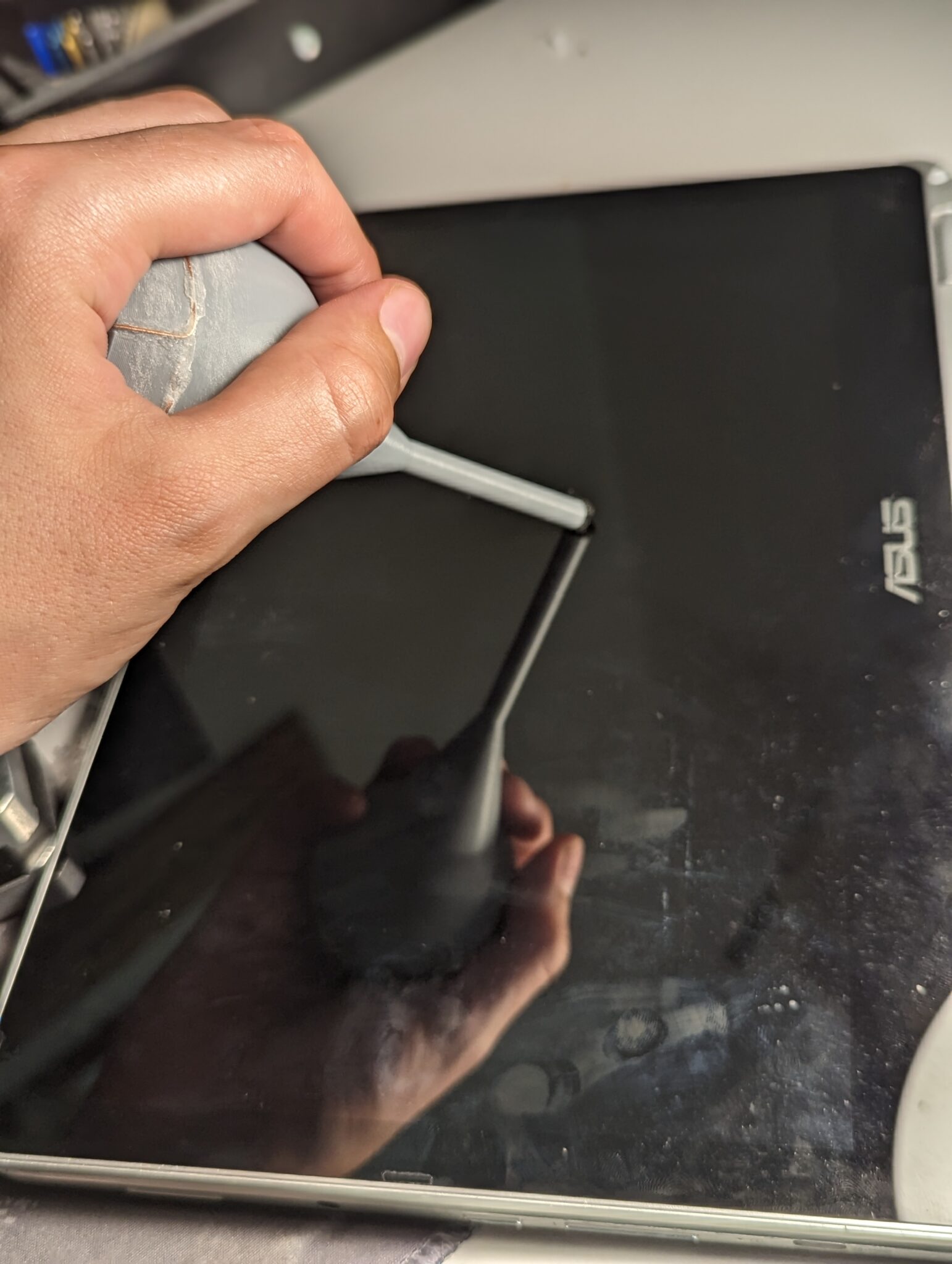 Person holding Palm Ball Stylus and pressing the tip against a touch screen.