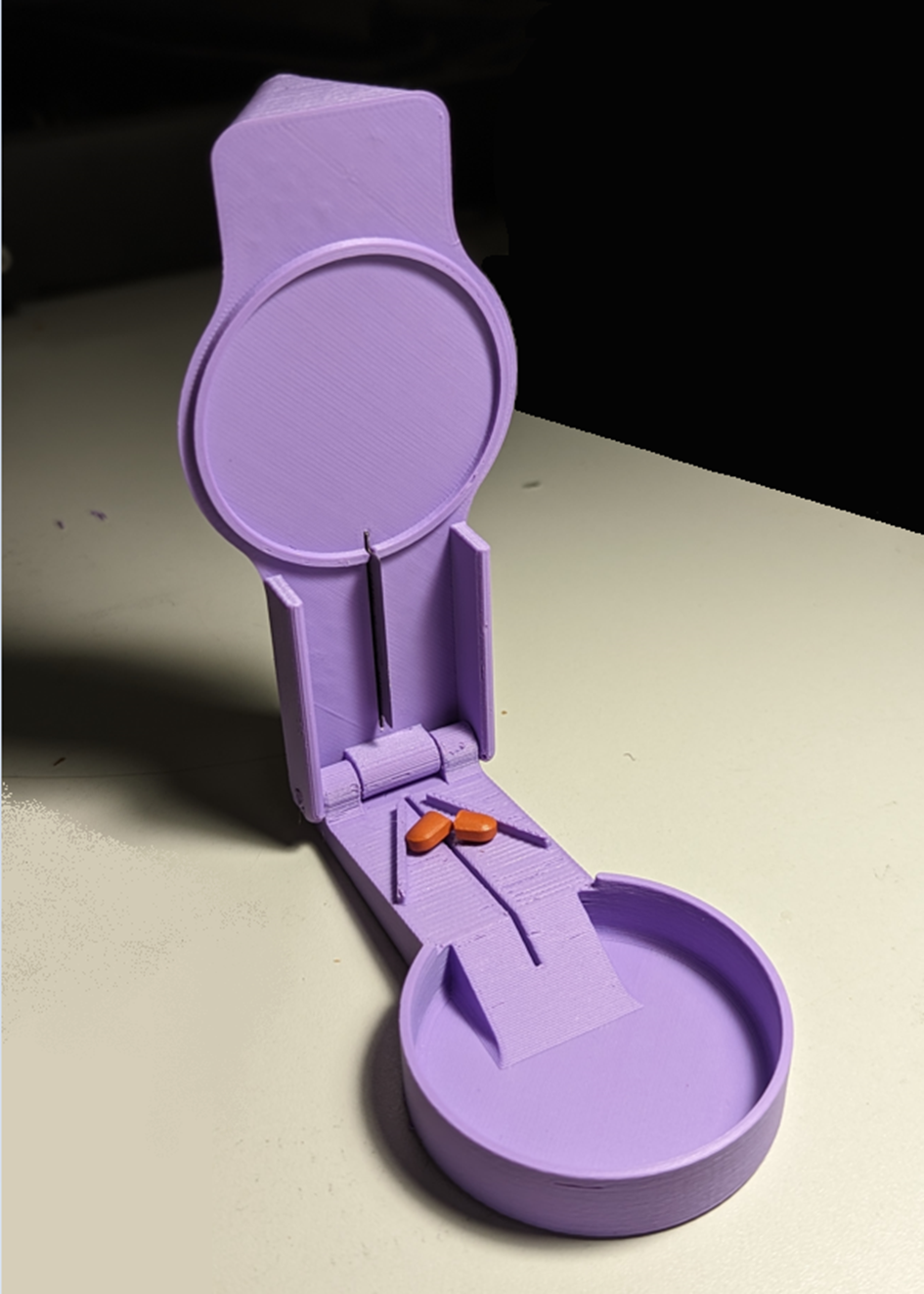 Pill splitter in the open position with a pill inside that has be cut into 2 pieces.