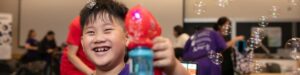 A young boy holding an adapted bubble blower.