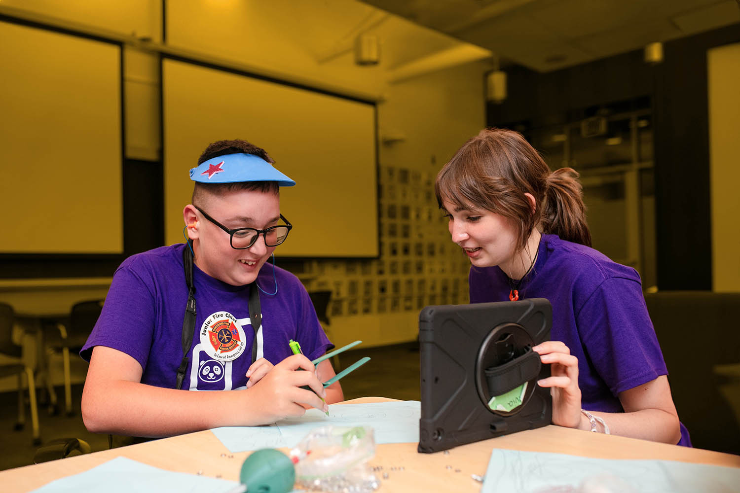 A child and a clinician use assistive technology.