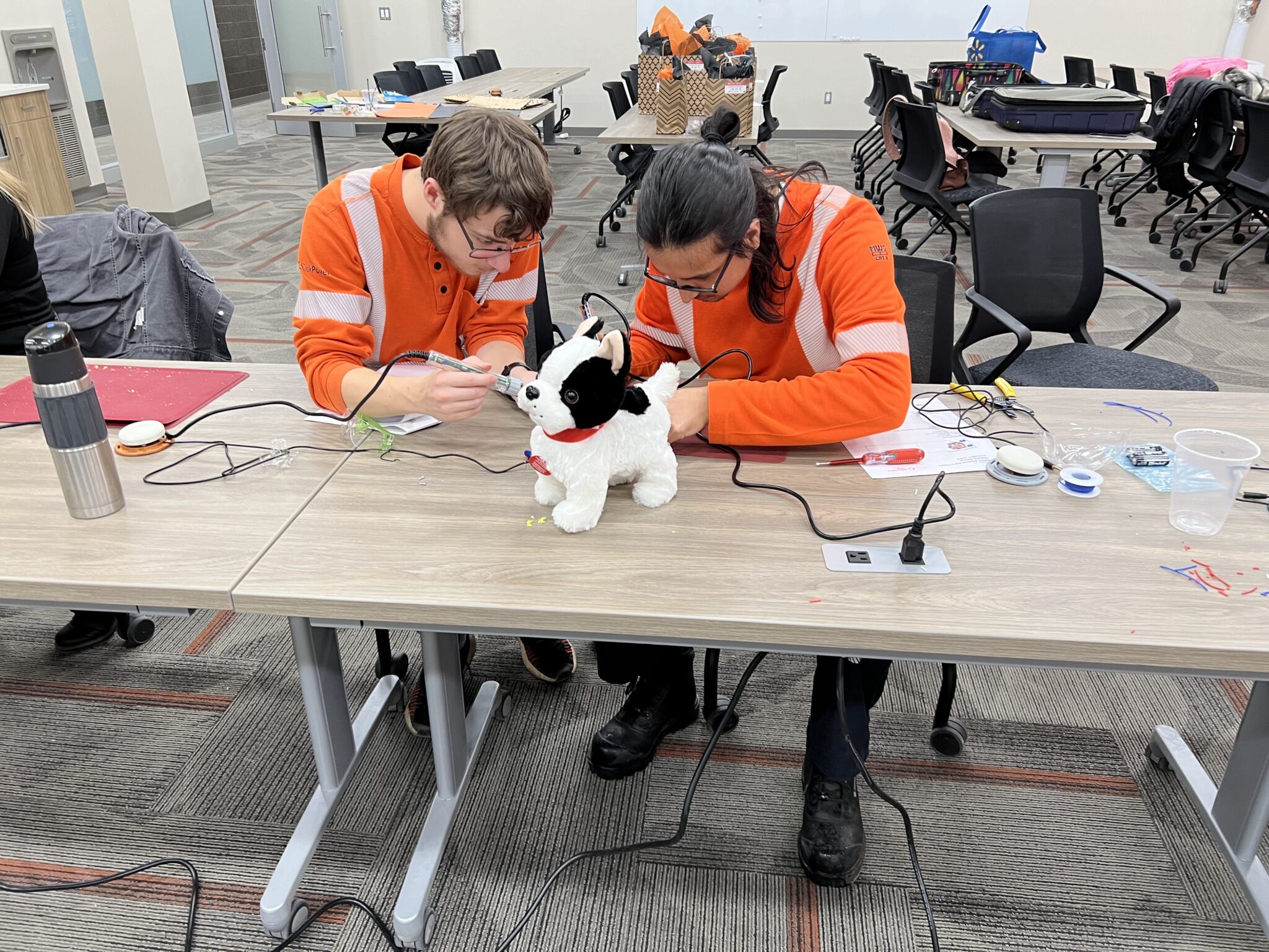 Two SaskPower employees work together to adapt a toy.