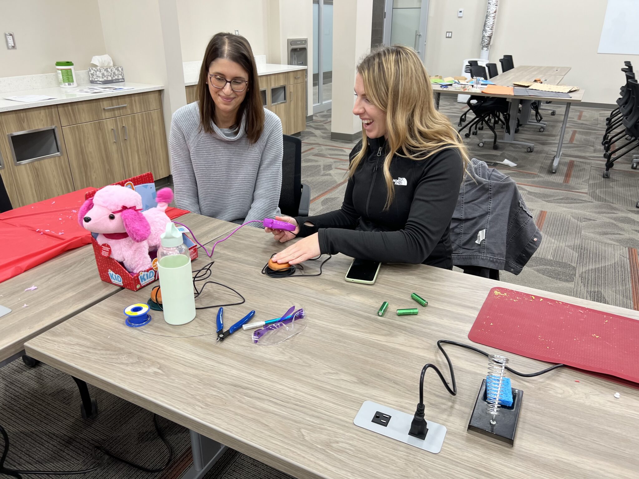 Two SaskPower employees work together to adapt a toy.