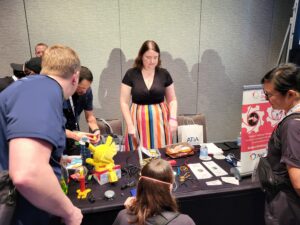 MMC East Region Coordinator Courtney at the MMC booth talking to other ATIA participants.